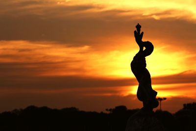 Low angle view of silhouette statue against sky during sunset