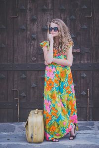 Portrait of young woman wearing sunglasses standing outdoors