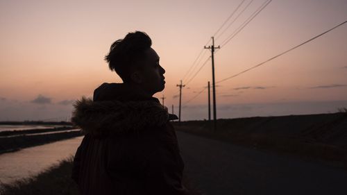 Silhouette of man on road against sky