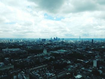 Aerial view of cityscape against cloudy sky