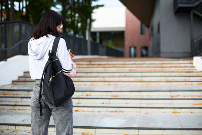 Rear view of woman standing on staircase