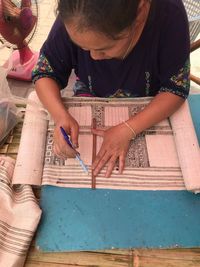 Woman drawing on textile in workshop