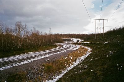 Road amidst trees against sky