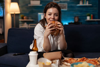 Portrait of young woman having food in restaurant