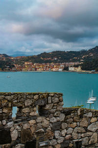 Scenic view of sea by townscape against sky