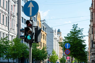 Traffic semaphore with green light on the background of defocused urban street, closeup