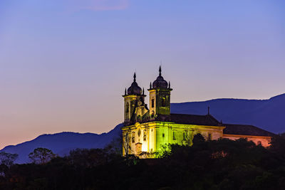 Illuminated building against sky at dusk