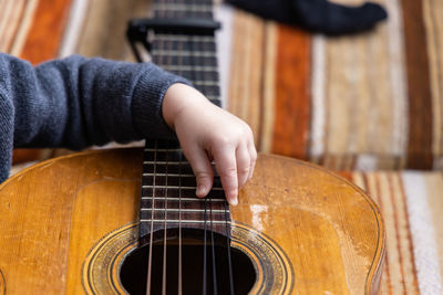 Midsection of woman playing guitar