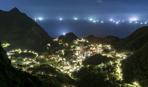 Illuminated city against sky at night