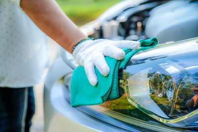Midsection of man cleaning car with towel