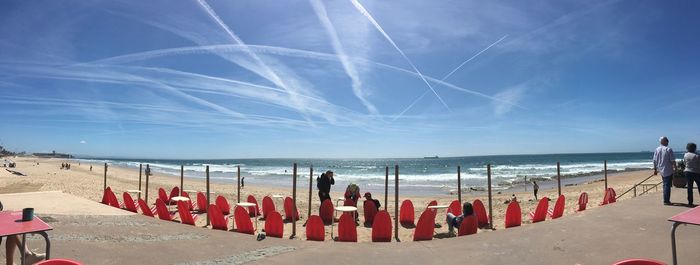 Panoramic shot of people on beach against sky