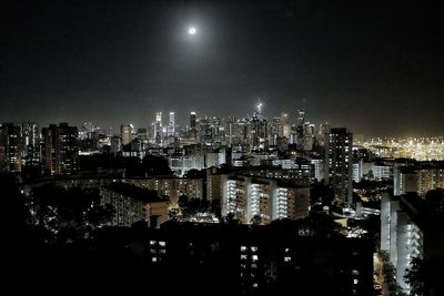 Illuminated cityscape against sky at night