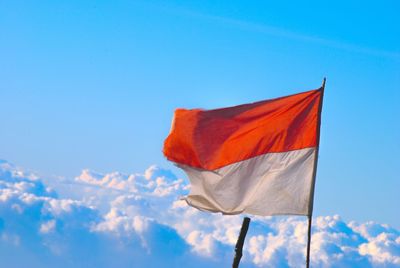 Low angle view of flag against blue sky