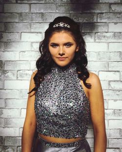 Portrait of woman standing against wall