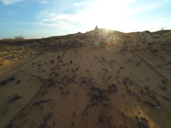 Scenic view of sand dunes against sky