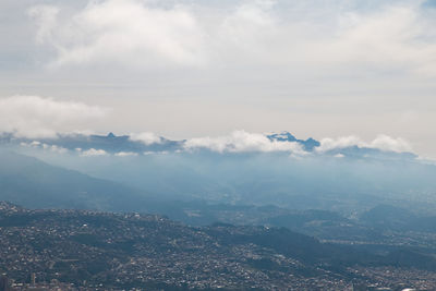 Aerial view of city and mountains against sky