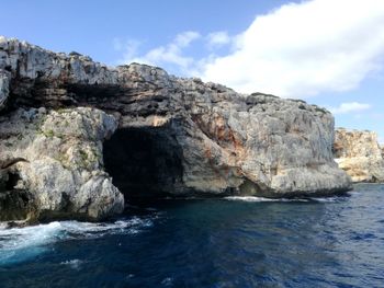 Rock formations by sea against sky