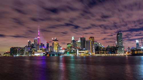 Illuminated buildings against sky at night