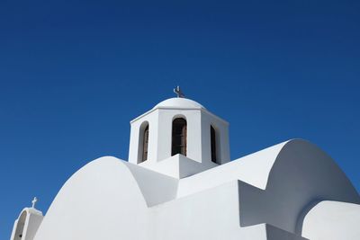 Low angle view of bell tower against clear blue sky