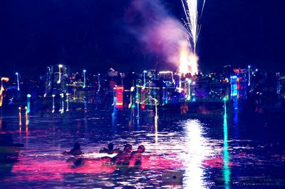 Illuminated city against sky at night