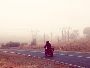 Woman cycling on country road