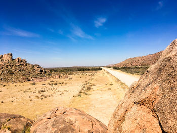 Scenic view of desert against blue sky