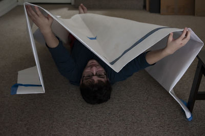 High angle view of man lying down on floor at home