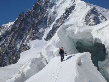 Full length of woman standing on snow covered hill