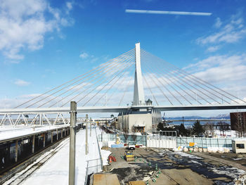 View of suspension bridge connection against cloudy sky 
