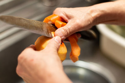 Close-up of person peeling fruits