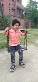 Full length of girl on swing at playground