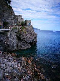 Scenic view of sea by buildings against sky