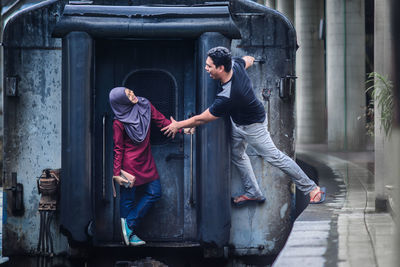 Playful couple on train at railroad station