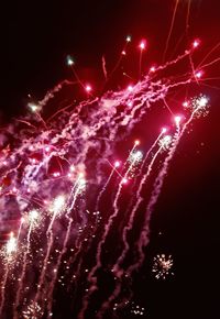 Low angle view of firework display at night