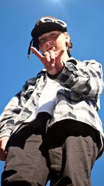 Low angle view of boy wearing sunglasses against clear sky