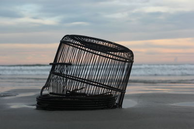 Lifeguard hut on beach against sky during sunset