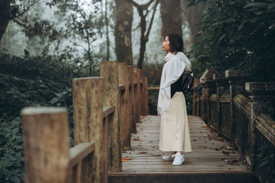 A woman standing in the forest in the cold weather.