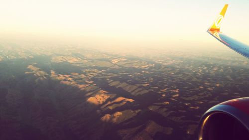 Aerial view of airplane wing over landscape