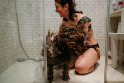 Young woman and dog in bathroom