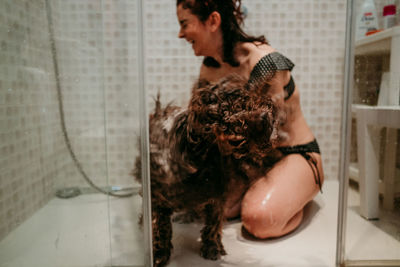 Young woman with arms raised in bathroom