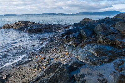 Landscape of black rocks on the coastline of the pacific ocean in anacortes, washington