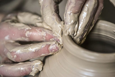 Hands in the clay macro. making crock crude wet close-up. man hands making clay jug macro. 