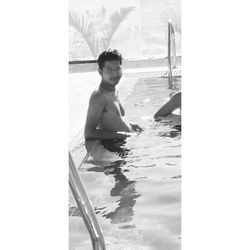 Portrait of shirtless man swimming in pool