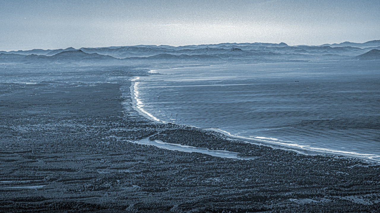 SCENIC VIEW OF SEA BY MOUNTAIN AGAINST SKY