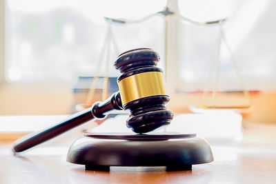 Close-up of gavel and weight scale on table in courtroom