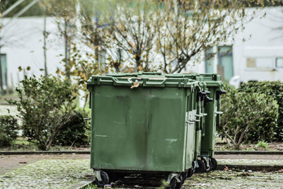 Garbage bin against trees in city