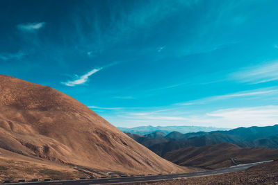 Scenic view of mountains against blue sky