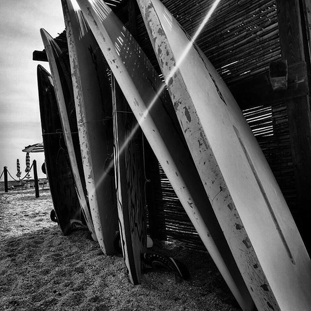 built structure, architecture, sky, beach, building exterior, sand, abandoned, wood - material, sunlight, day, no people, outdoors, shadow, damaged, wood, absence, in a row, obsolete, old, steps