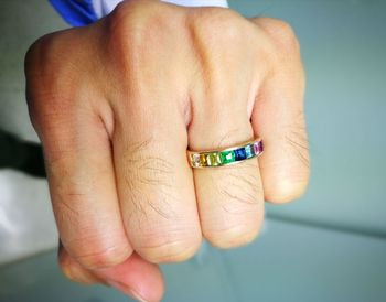 Cropped image of fist wearing colorful ring