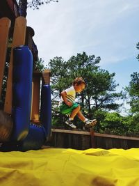 Low angle view of boy jumping in park